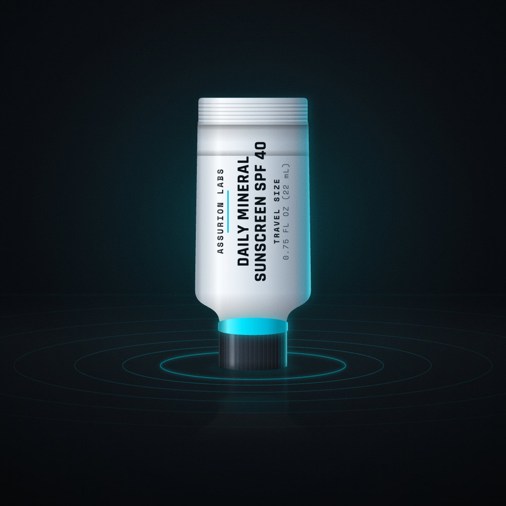 Mini frosted tube of Assurion Labs Travel Size Daily Mineral Sunscreen SPF 40 on a dark background